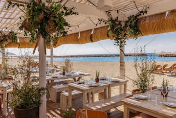 a beach restaurant with tables and chairs