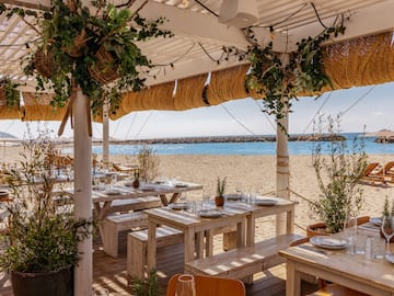 a beach restaurant with tables and chairs