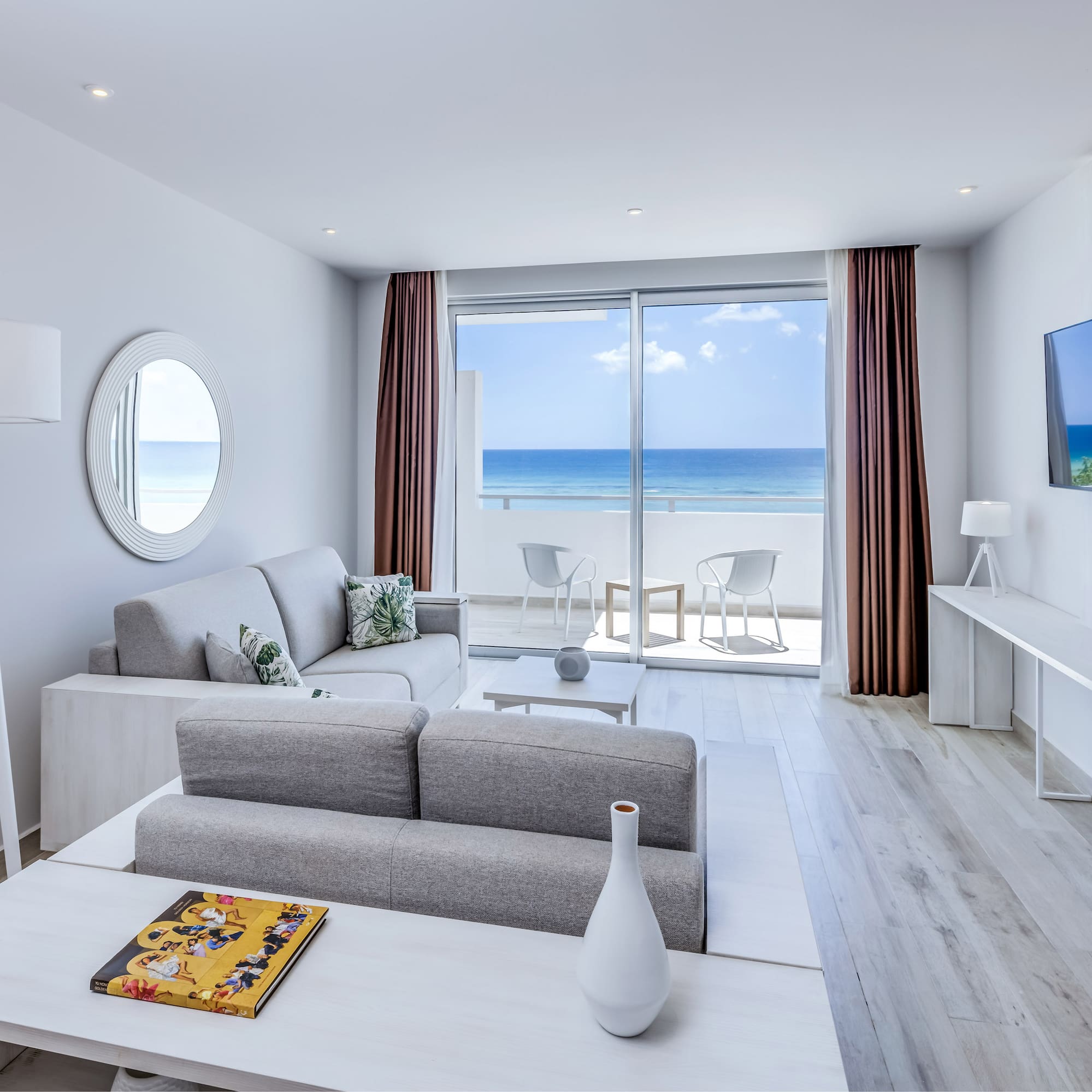 a living room with a television and a view of the ocean