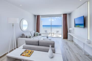 a living room with a television and a view of the ocean