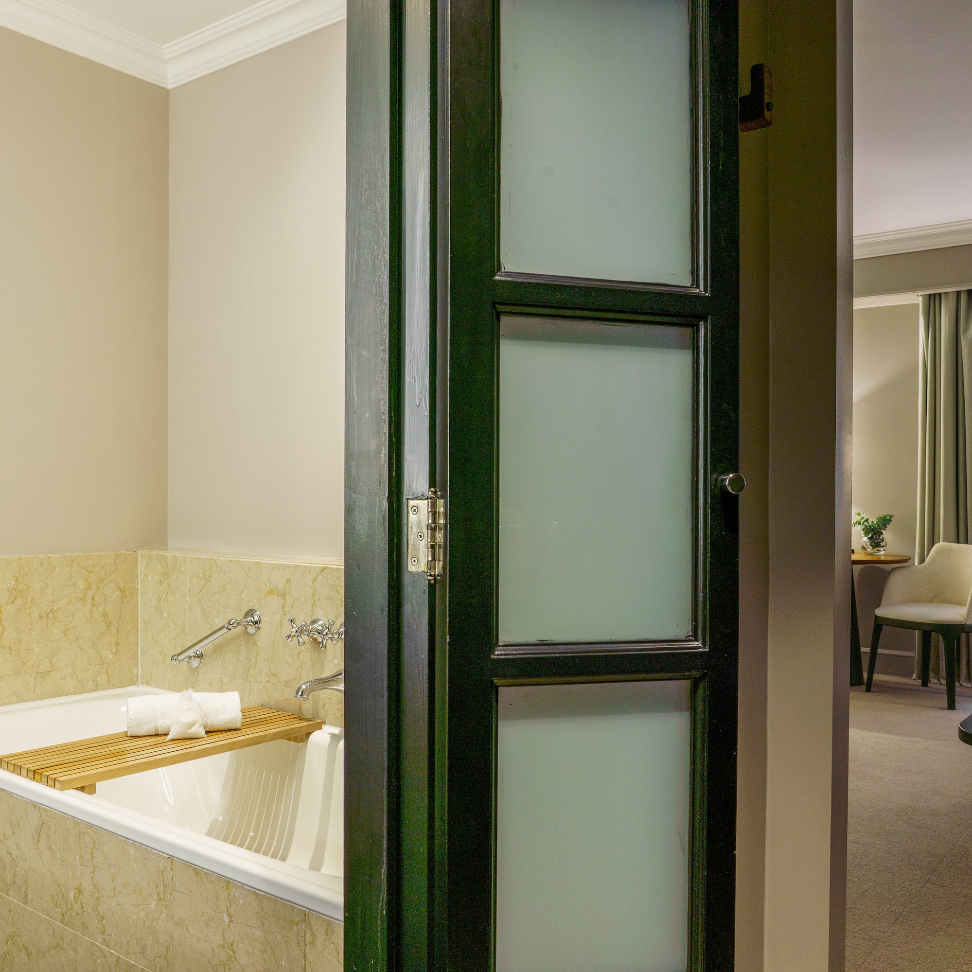 a bathroom with a tub and a chair