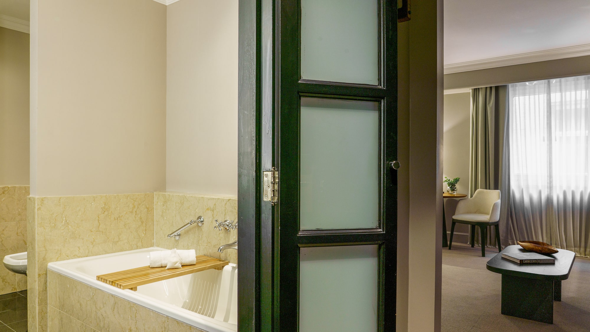 a bathroom with a tub and a chair