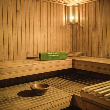 a wooden sauna with a bowl and a towel
