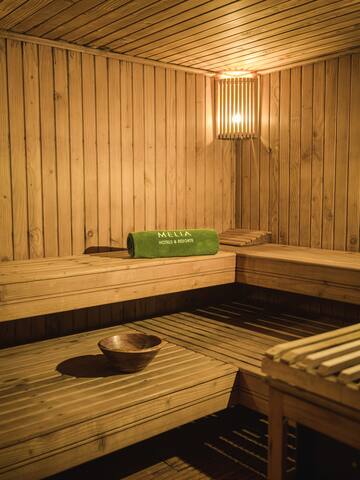 a wooden sauna with a bowl and a towel