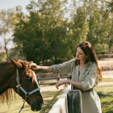 a woman petting a horse