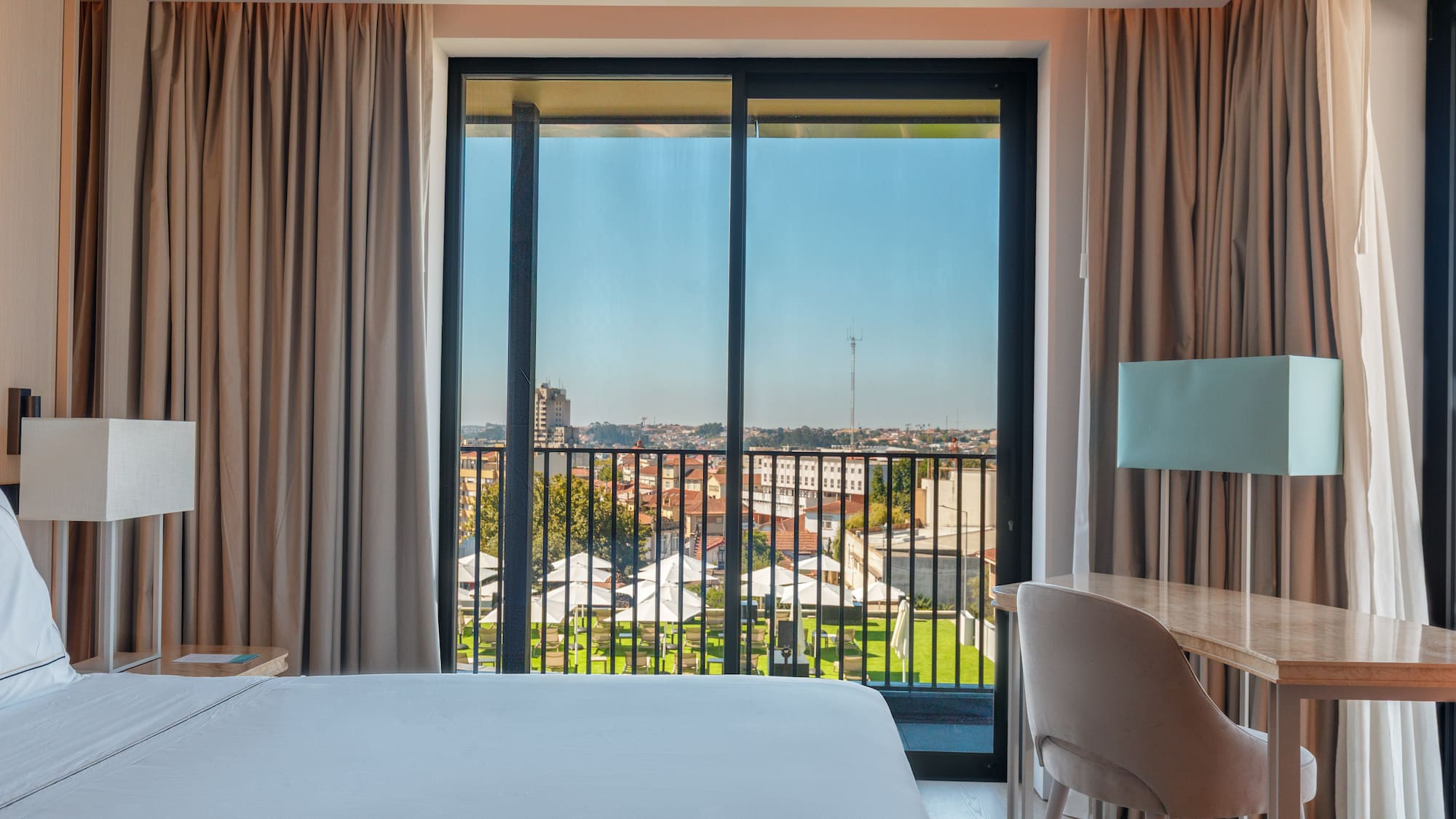 a room with a bed and a table and chairs and a balcony