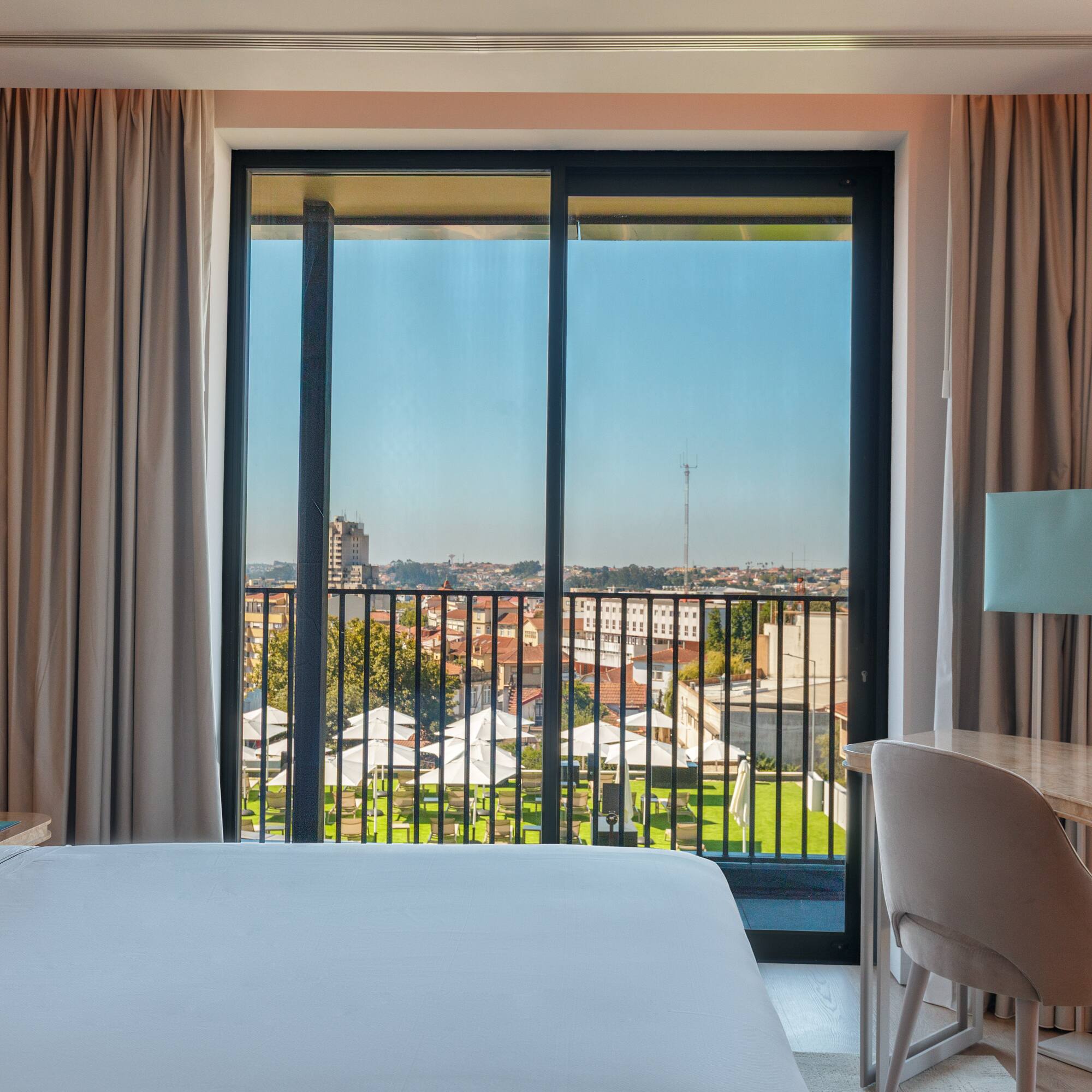 a room with a bed and a table and chairs and a balcony