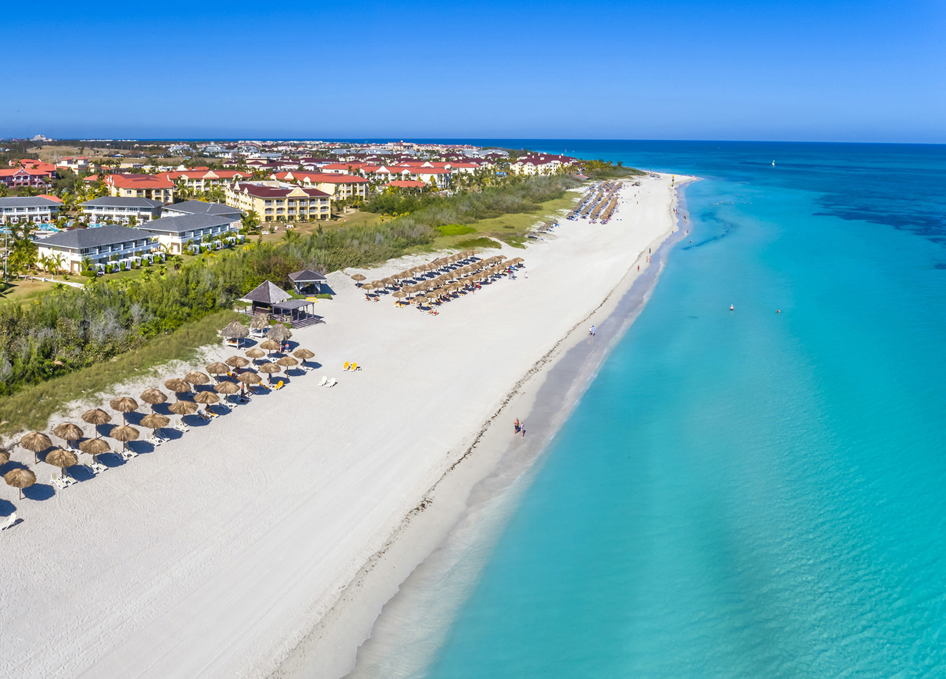 a beach with umbrellas and buildings