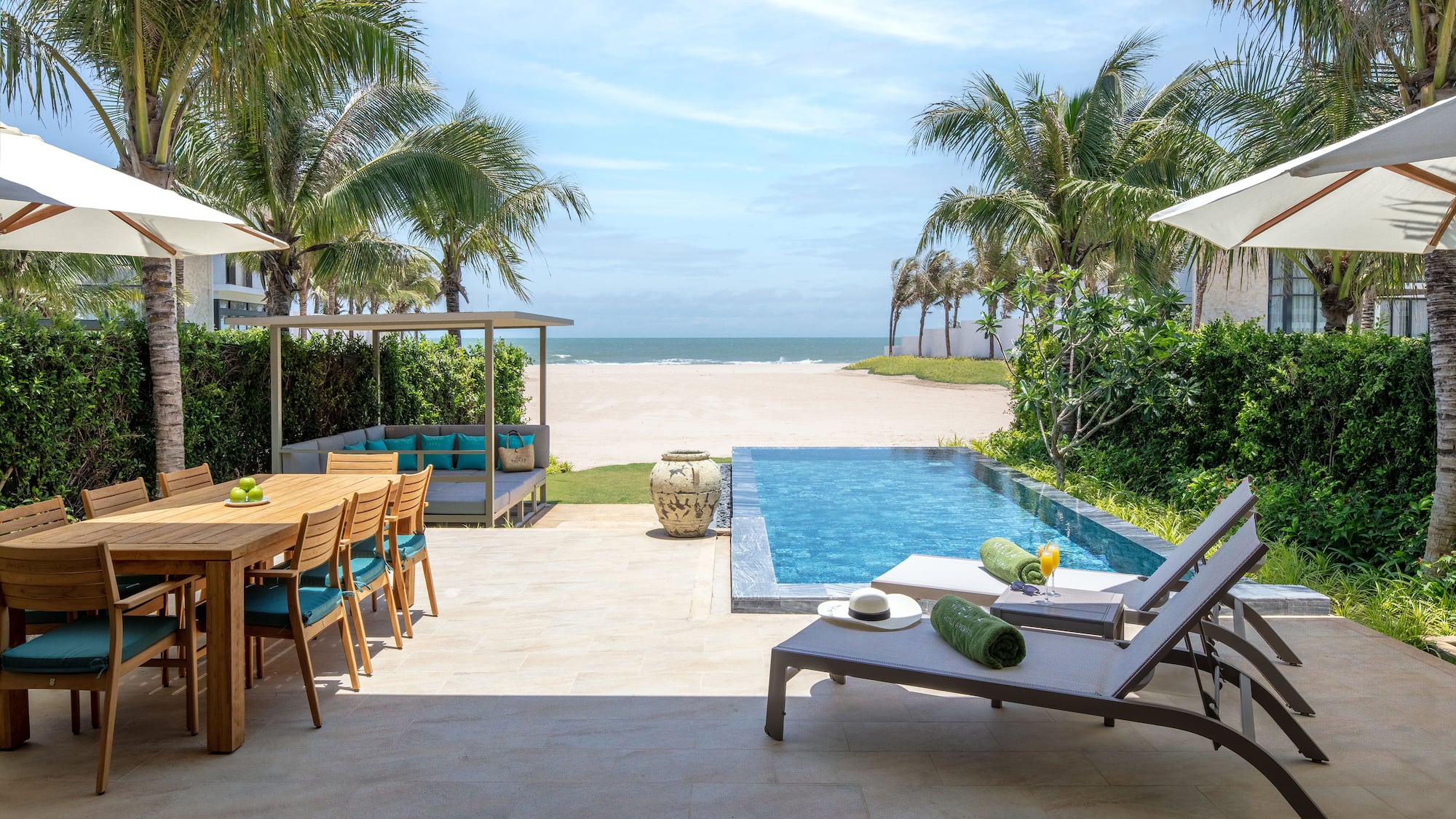 Tropical beachfront villa with private pool, outdoor dining, and sun loungers.