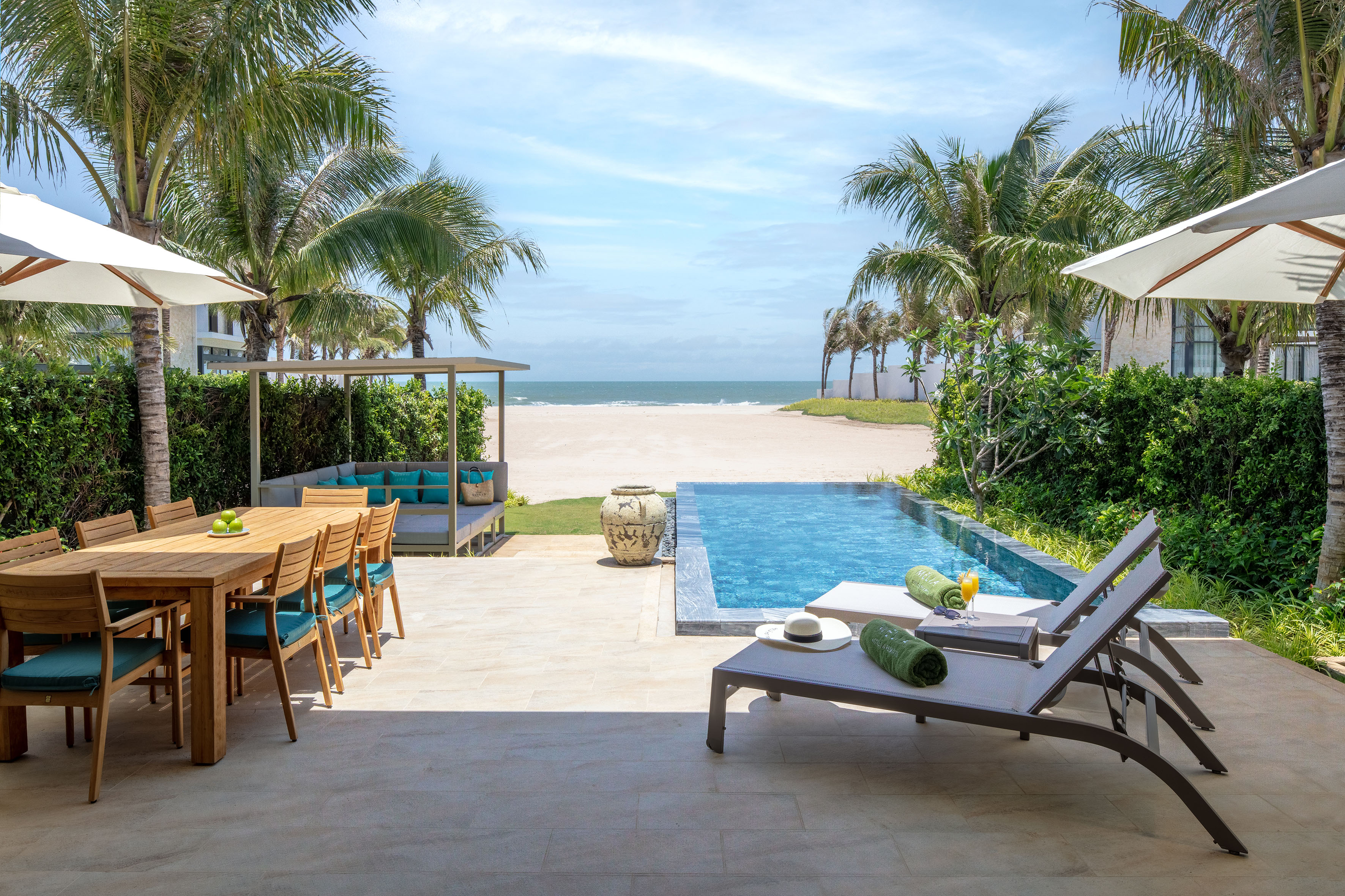 Tropical beachfront villa with private pool, outdoor dining, and sun loungers.