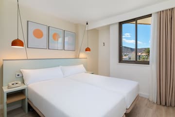 a bed with white sheets and a lamp