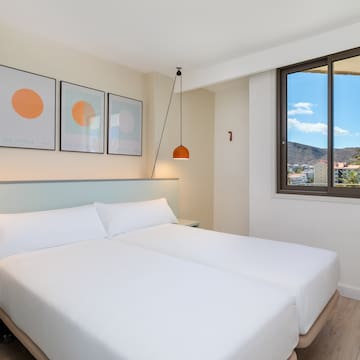 a bed with white sheets and a lamp