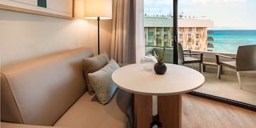 a couch and table with a lamp in front of a glass door