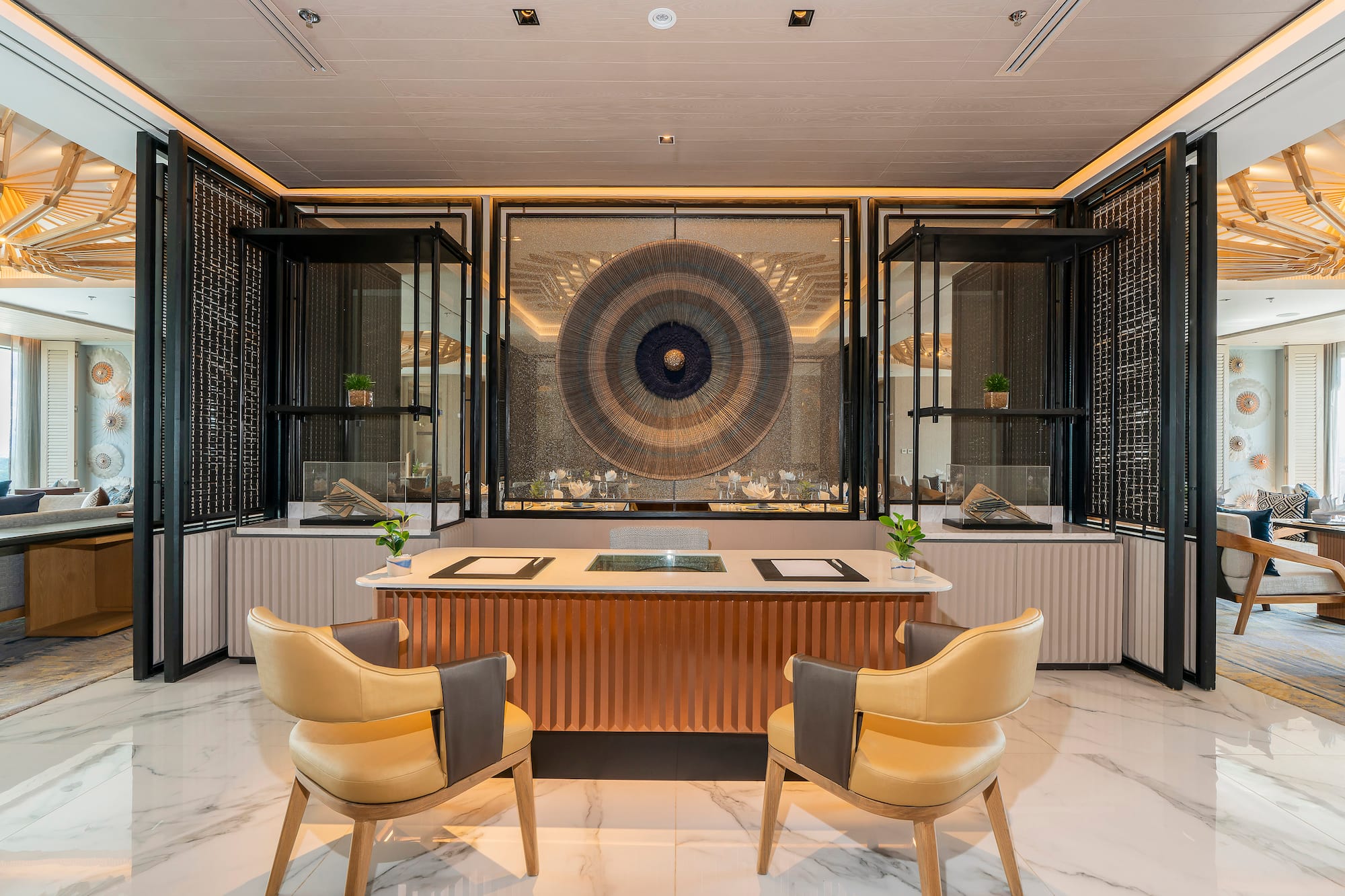Elegant reception with modern desk, yellow chairs, and striking circular wall art.