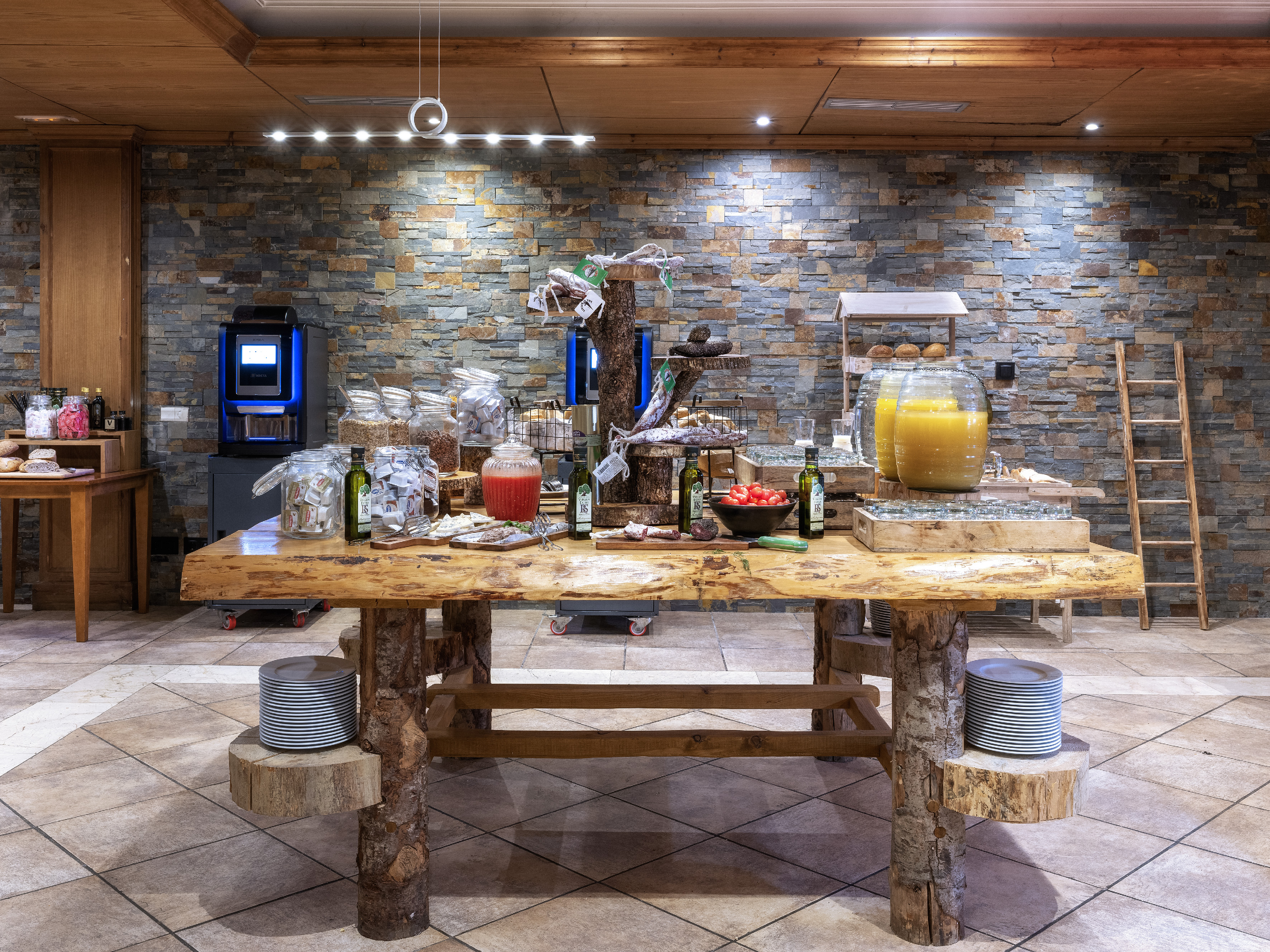 Rustic hotel breakfast buffet featuring fresh juices, cured meats, and bread.