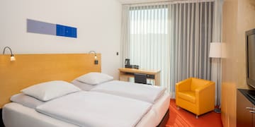 a room with two beds and a chair