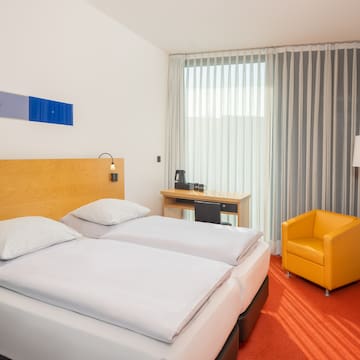 a room with two beds and a chair