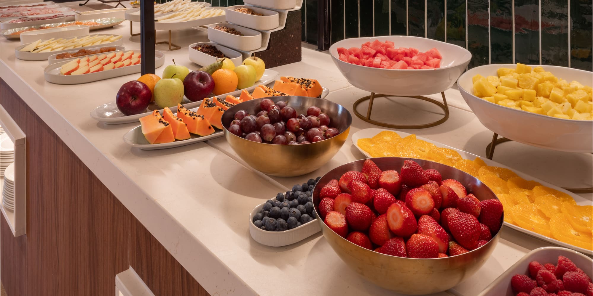 Hotel breakfast buffet with fresh fruit, berries, cheese, and cold cuts.