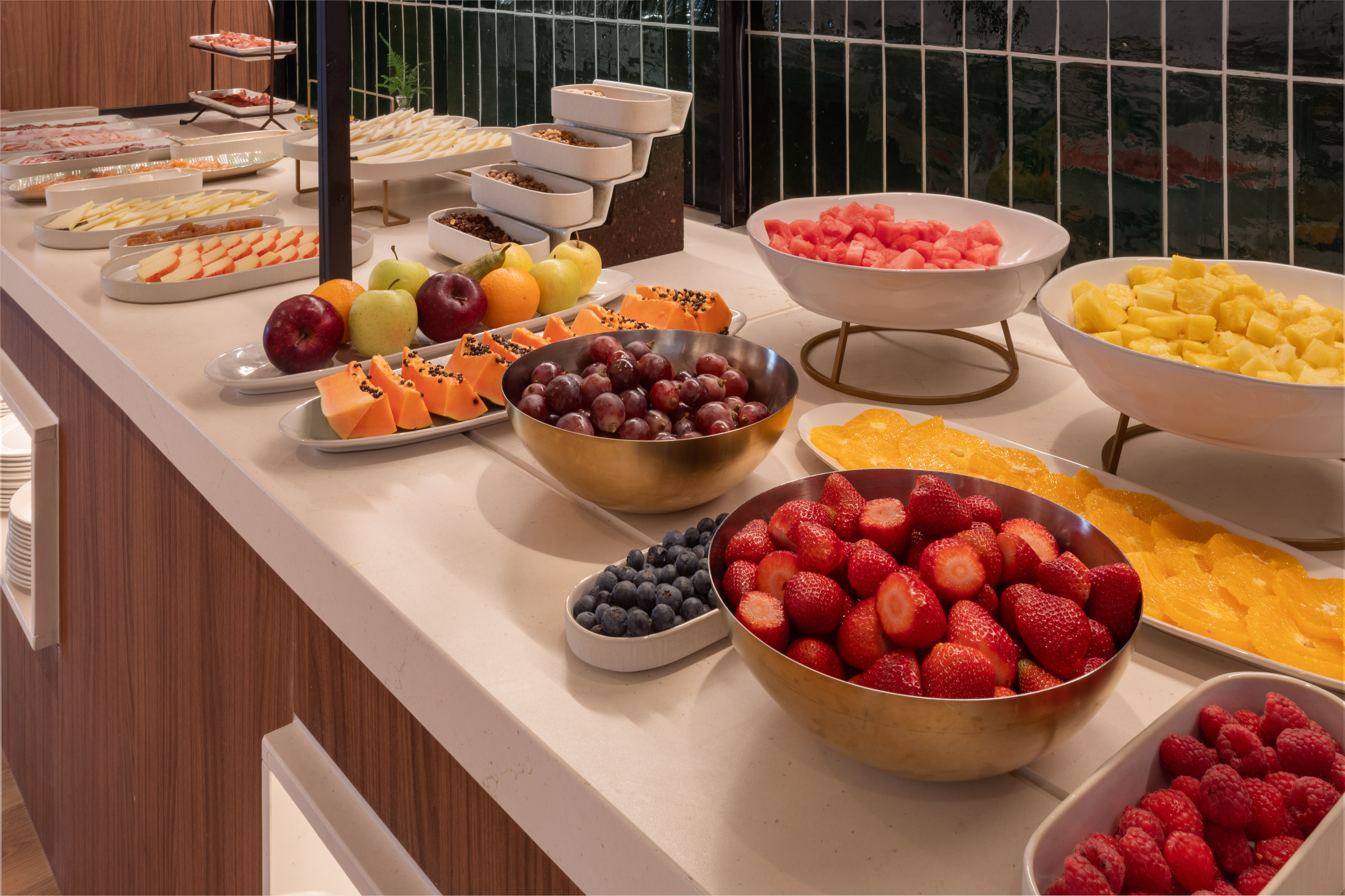 Hotel breakfast buffet with fresh fruit, berries, cheese, and cold cuts.