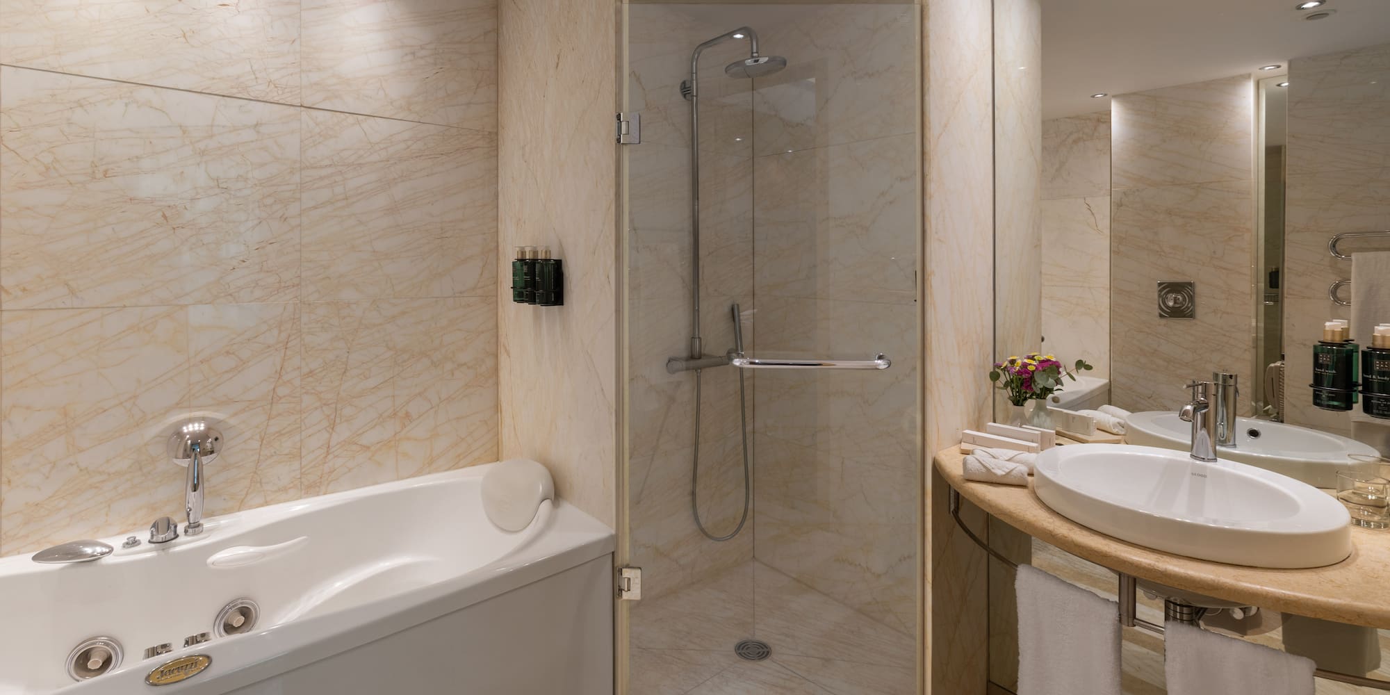 Luxurious marble bathroom with jacuzzi tub, walk-in shower, and elegant vanity.