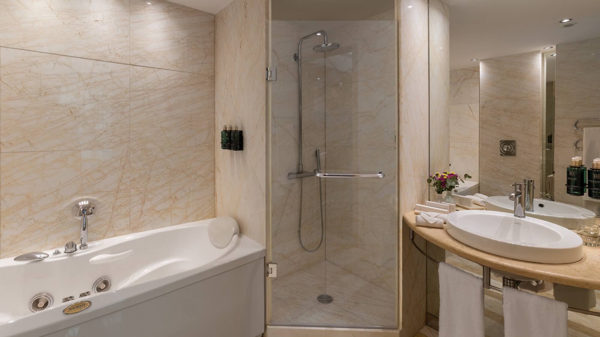 Luxurious marble bathroom with jacuzzi tub, walk-in shower, and elegant vanity.