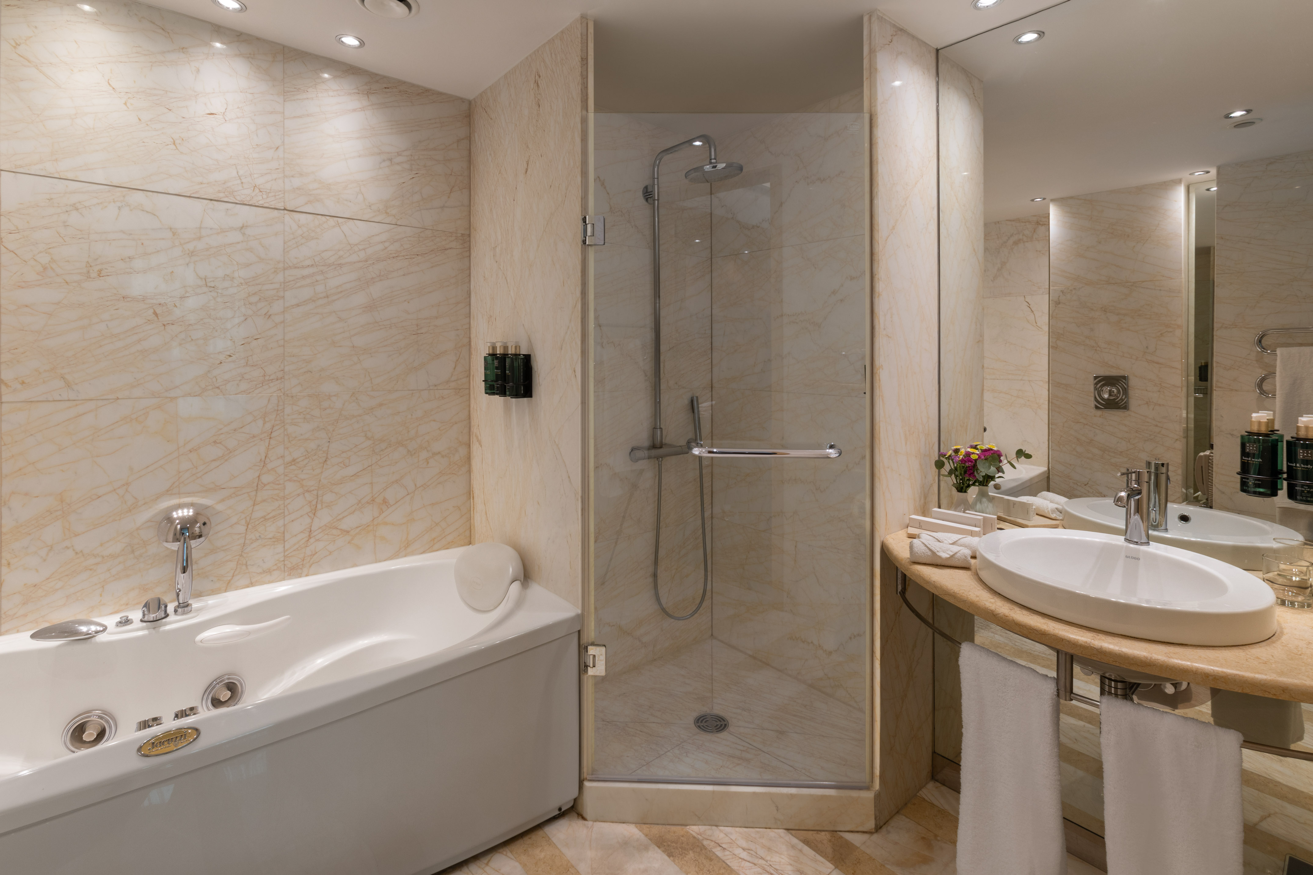 Luxurious marble bathroom with jacuzzi tub, walk-in shower, and elegant vanity.