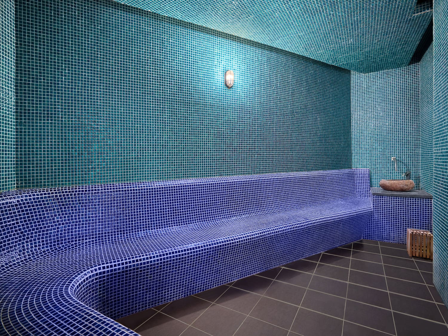 a blue tiled bench in a room