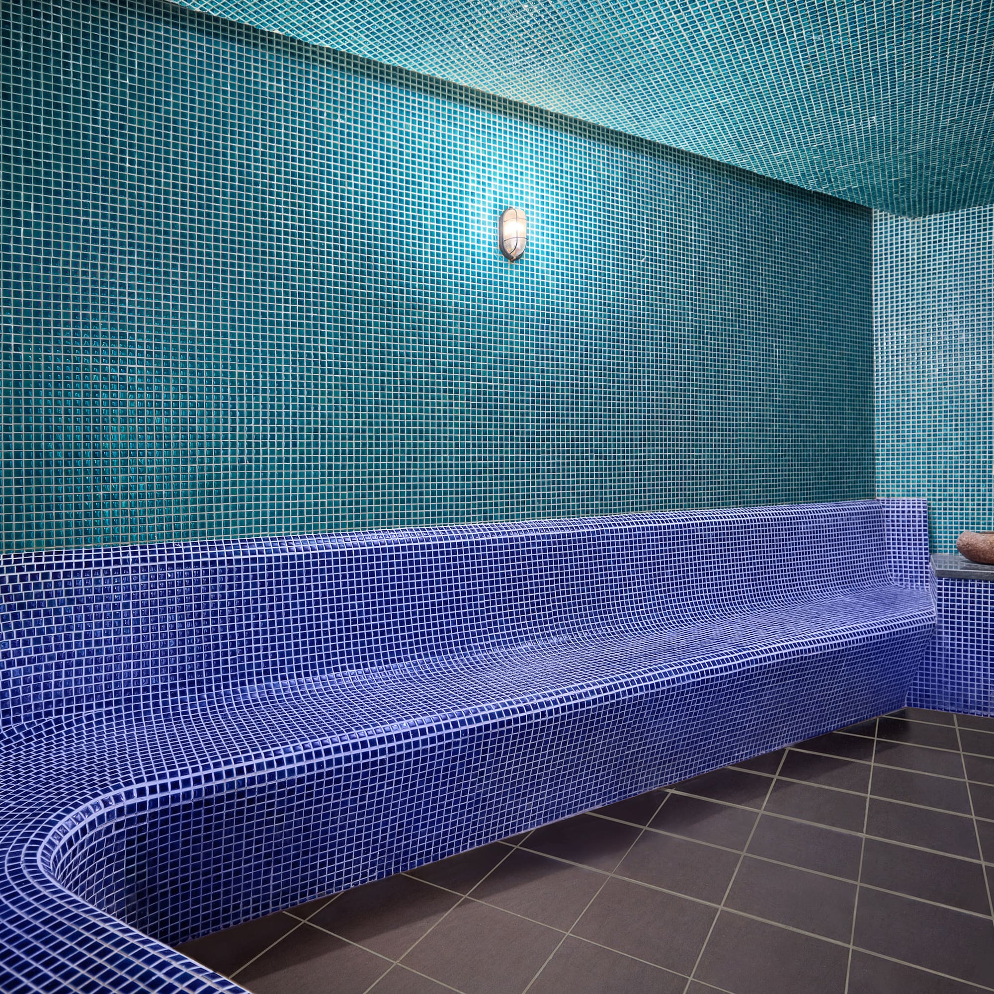 a blue tiled bench in a room