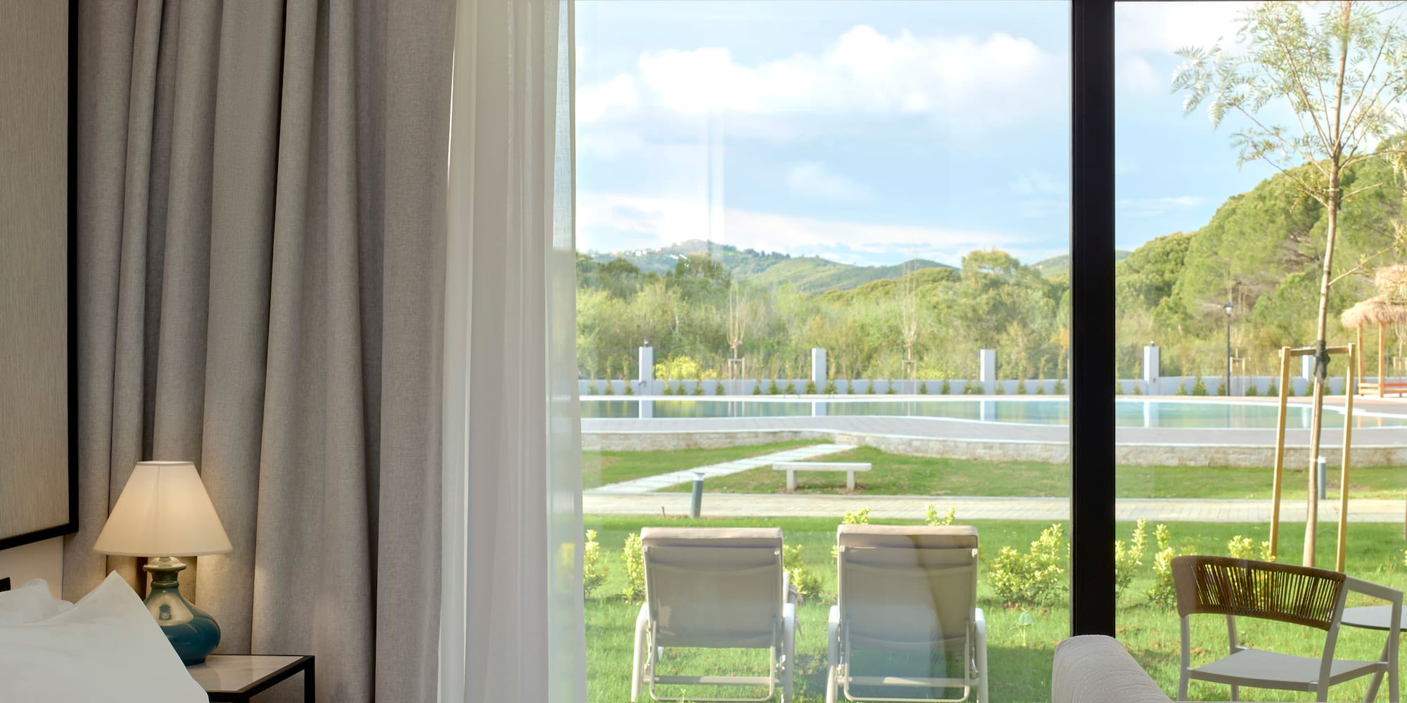 a room with a view of a pool and chairs