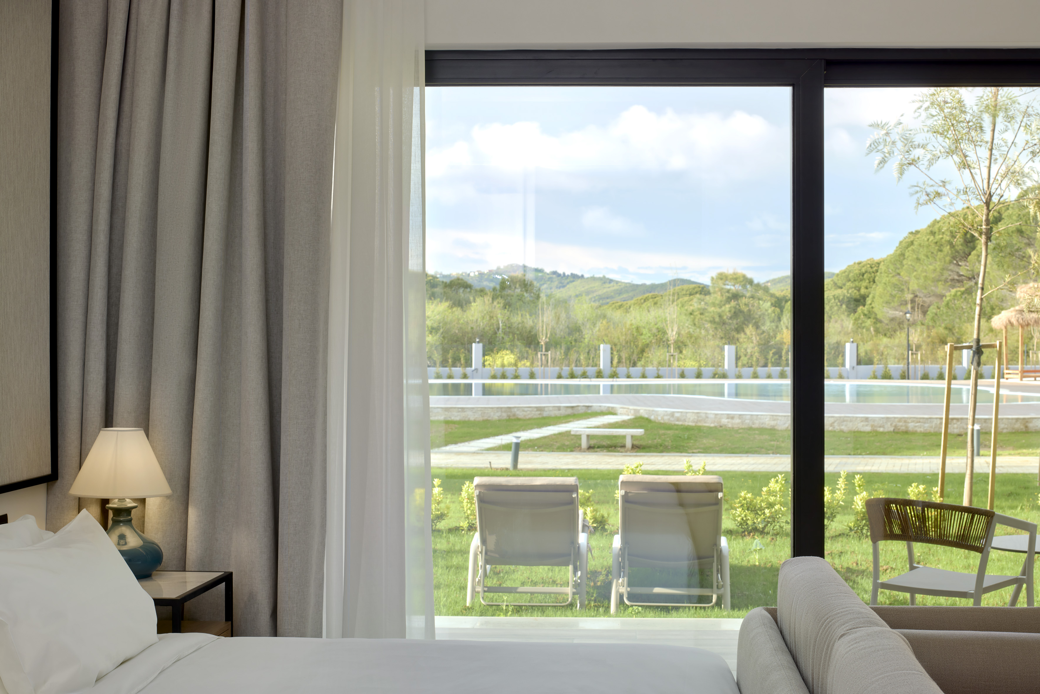 a room with a view of a pool and chairs