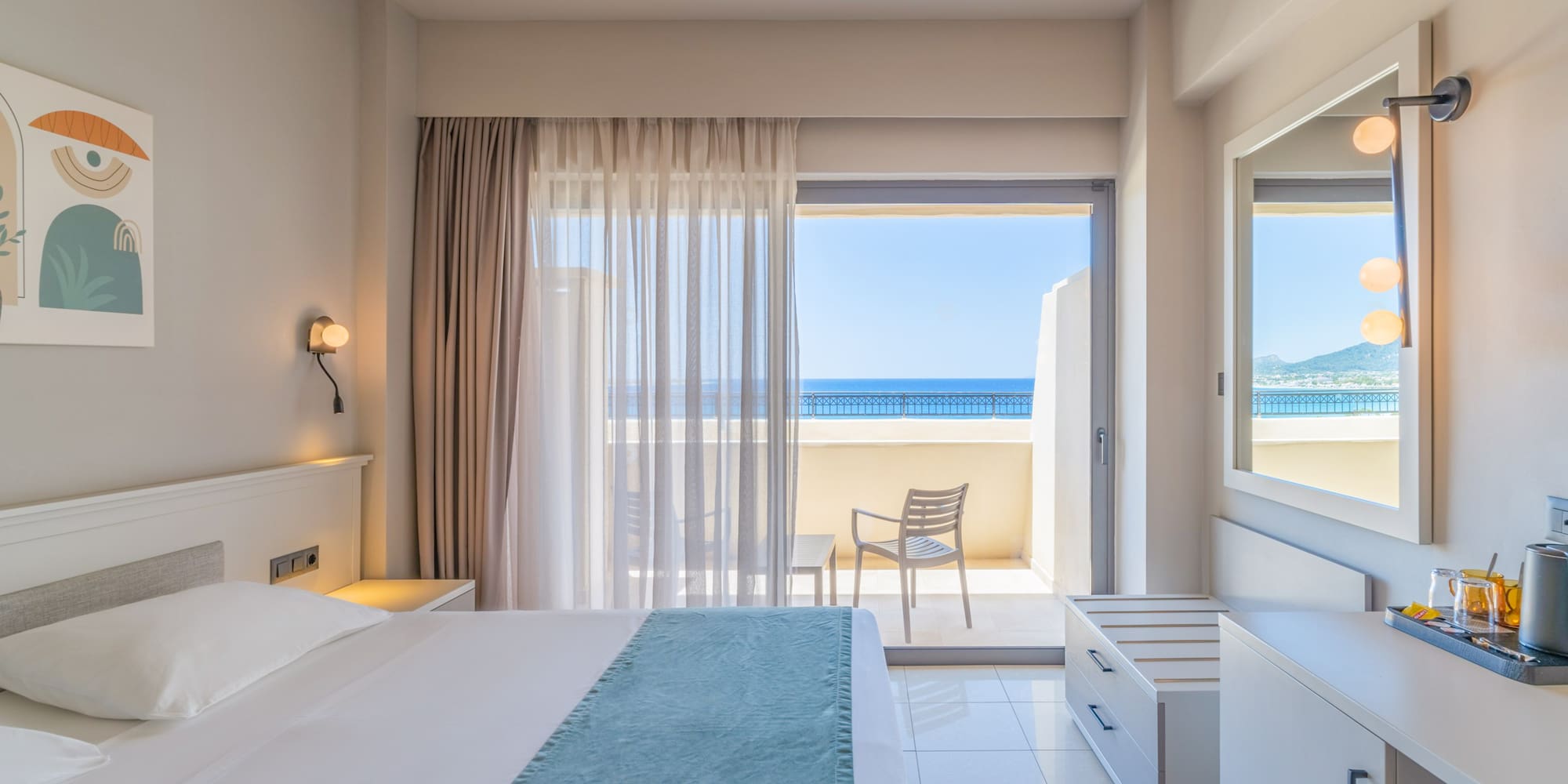 Bright hotel bedroom with sea view balcony and contemporary furnishings.