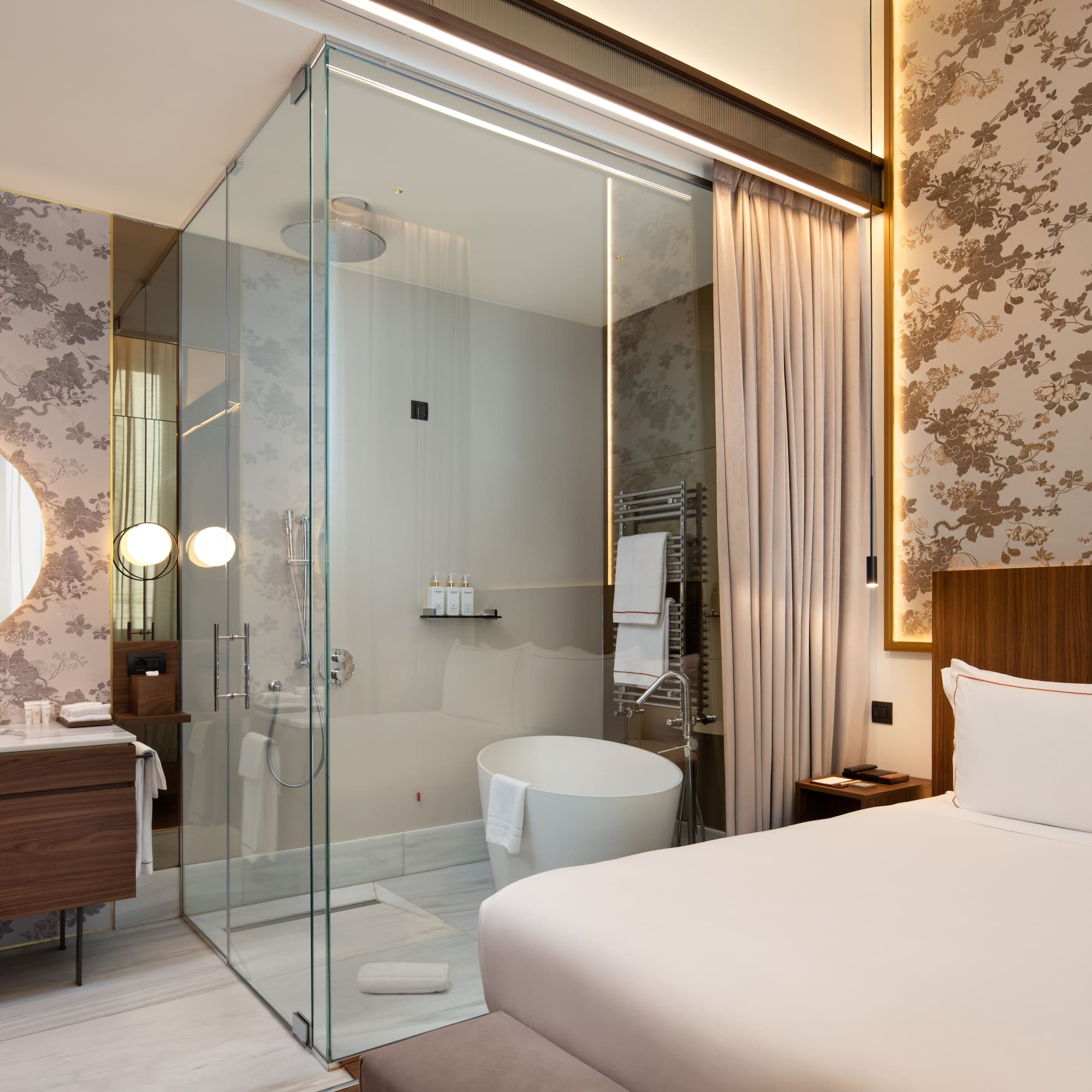 a room with a glass shower and a bed
