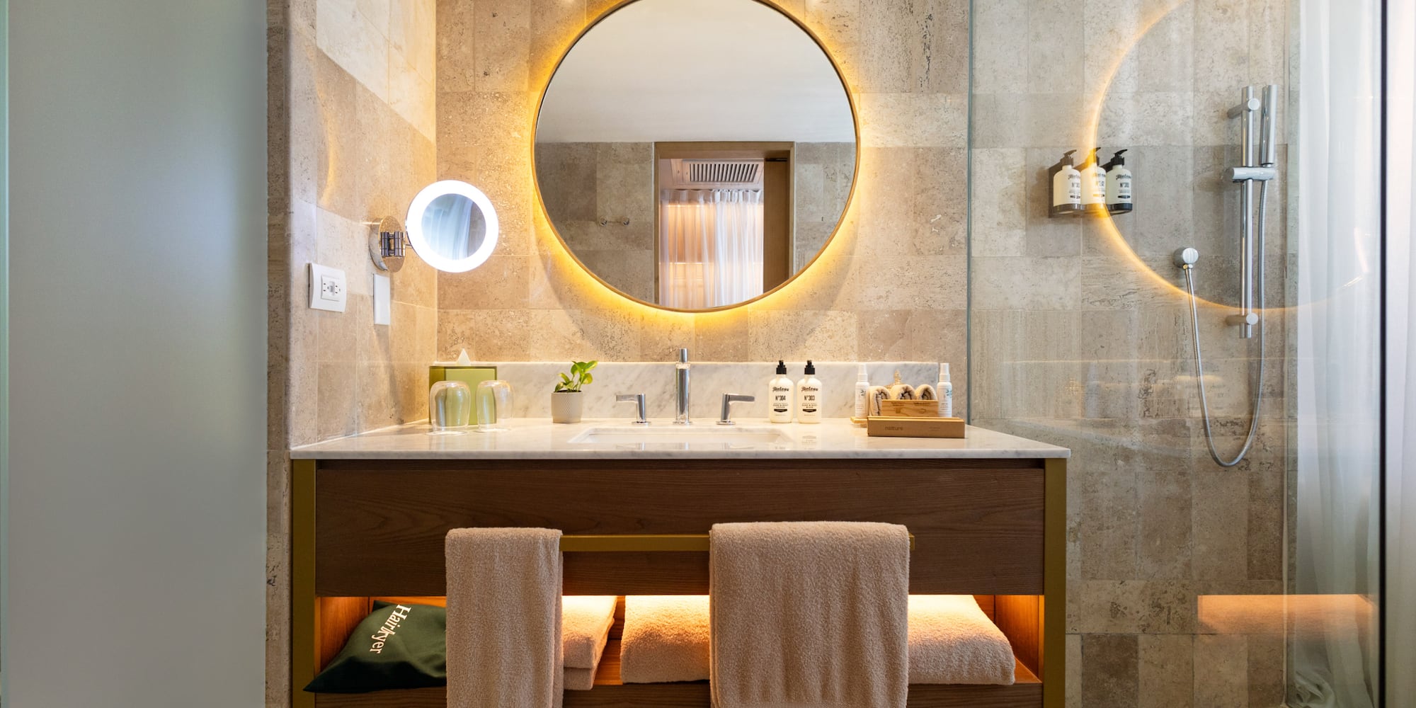 a bathroom with a round mirror and a sink