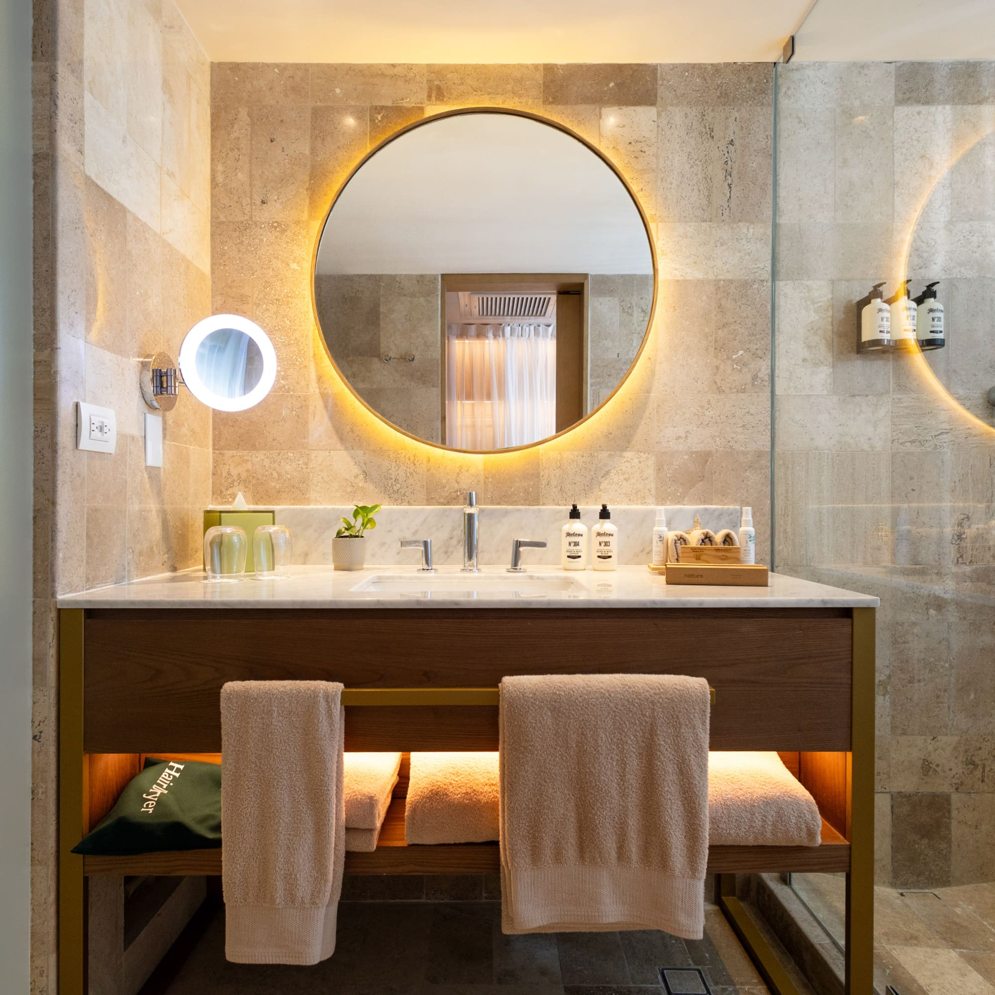 a bathroom with a round mirror and a sink