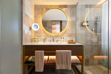 a bathroom with a round mirror and a sink