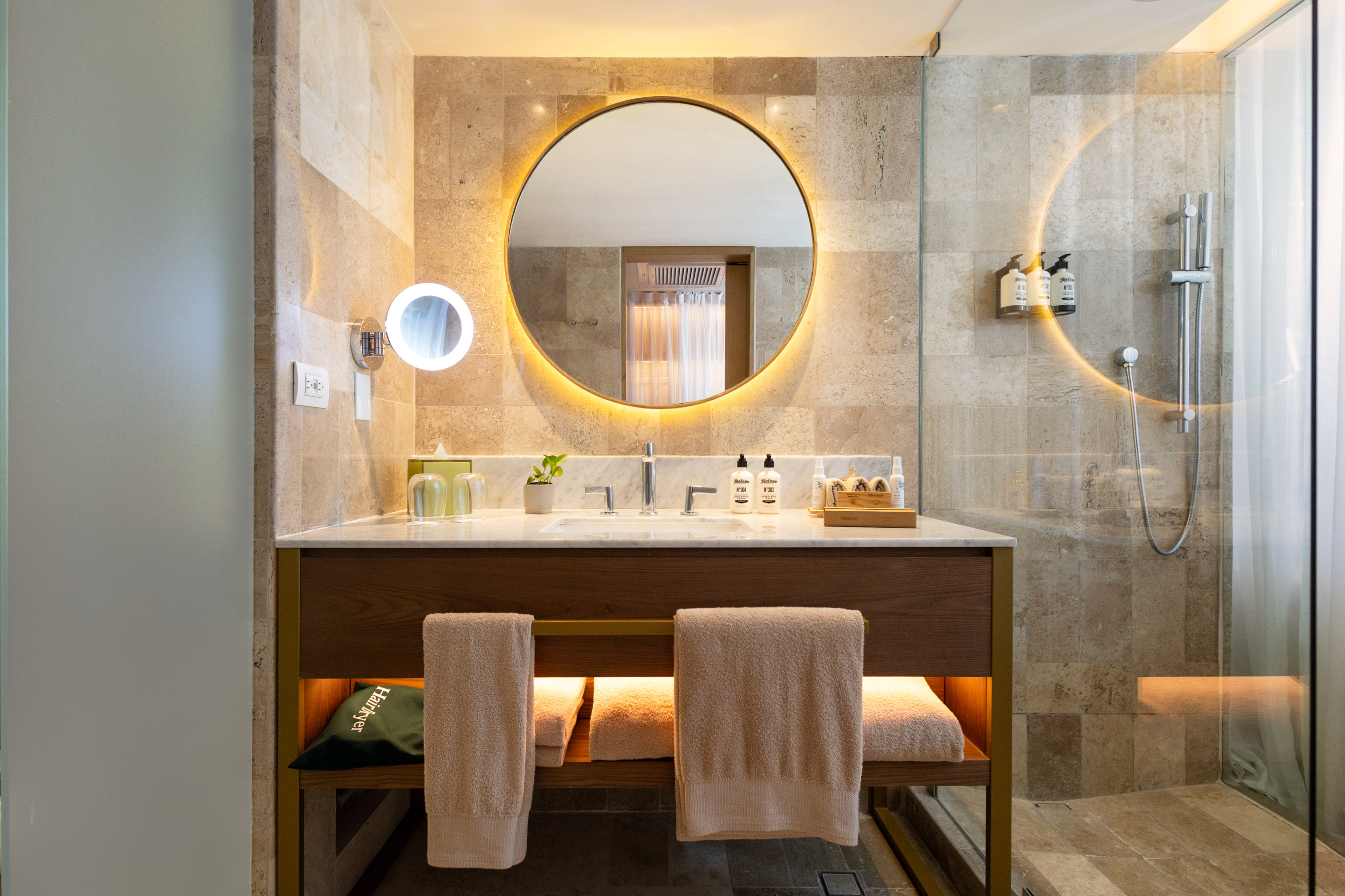 a bathroom with a round mirror and a sink