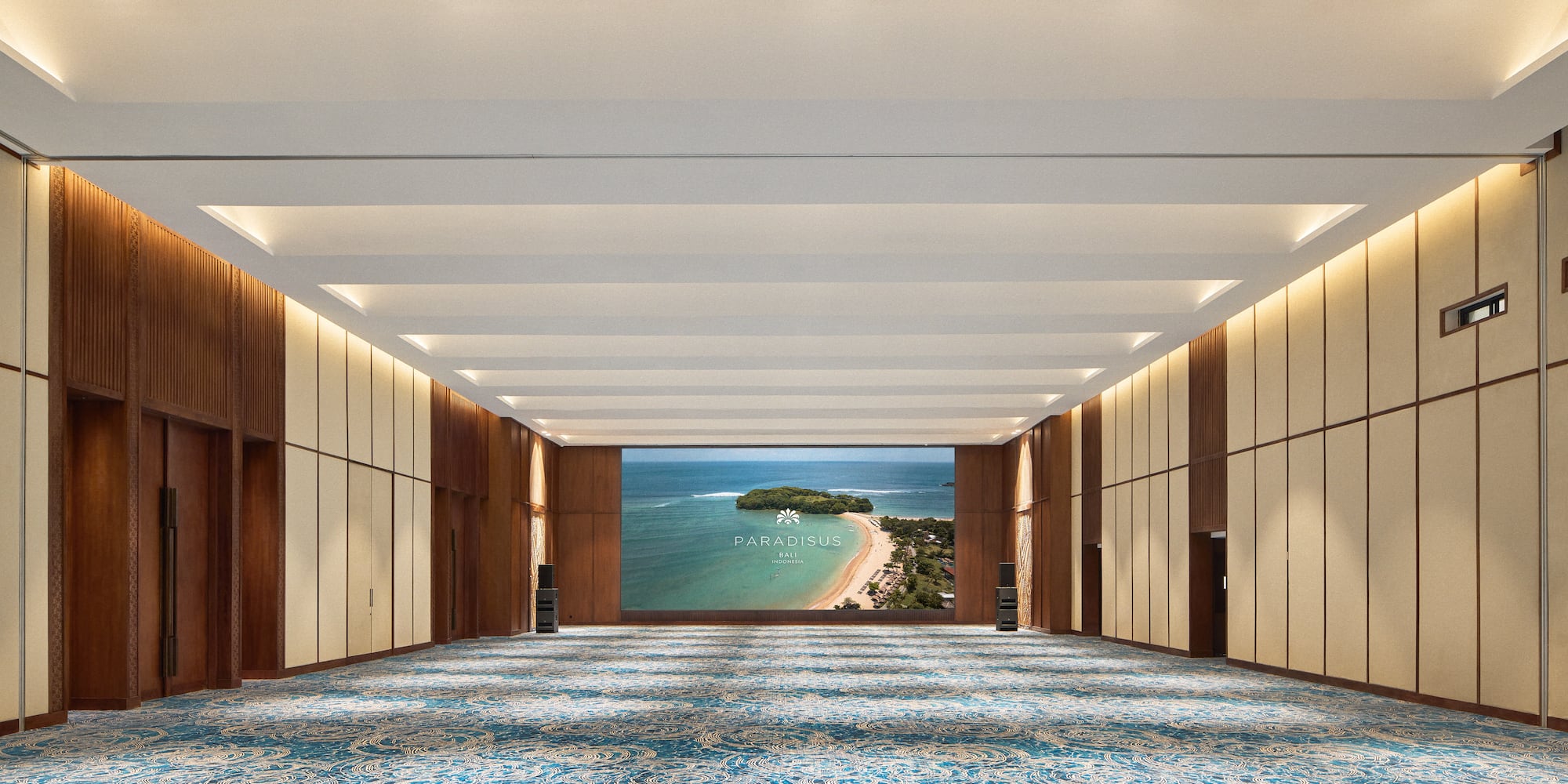 a large room with blue carpet and a view of the ocean
