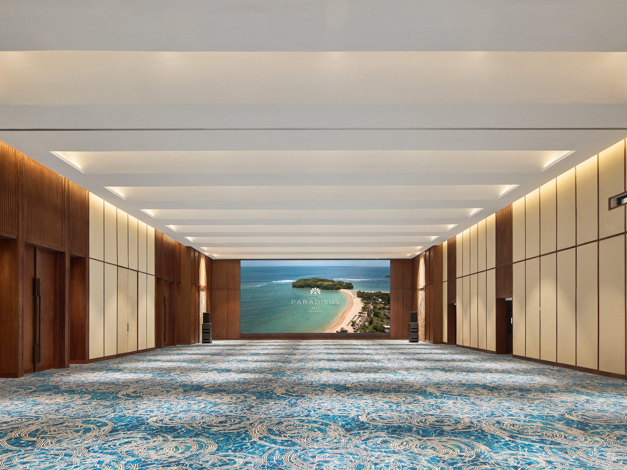 a large room with blue carpet and a view of the ocean