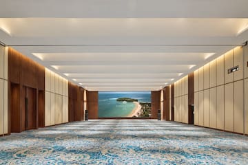 a large room with blue carpet and a view of the ocean