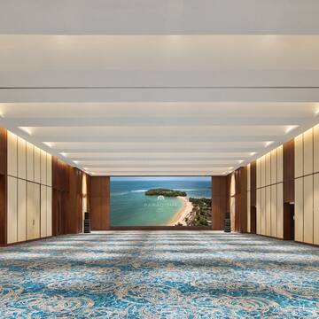 a large room with blue carpet and a view of the ocean
