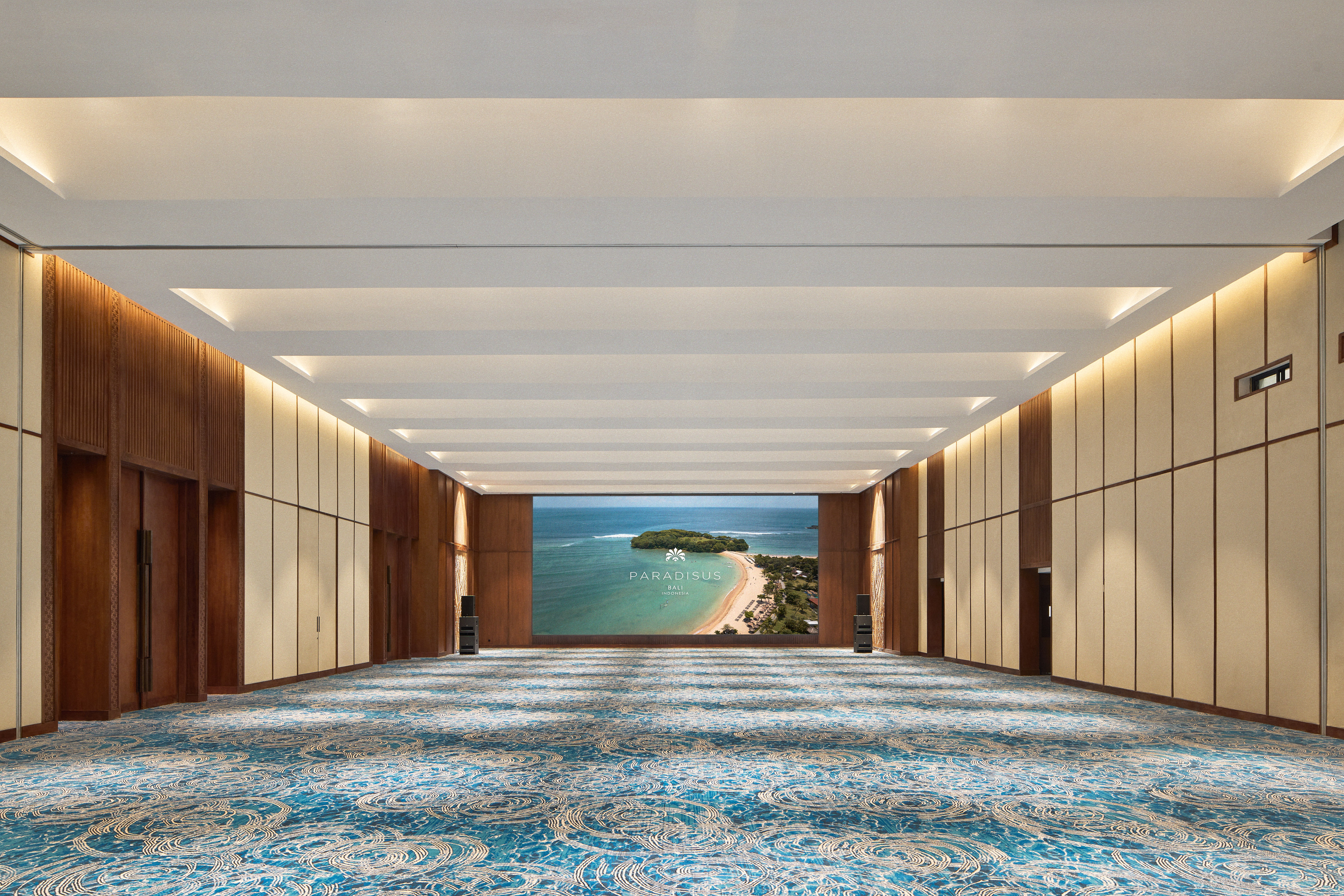 a large room with blue carpet and a view of the ocean