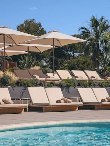 a pool with lounge chairs and umbrellas