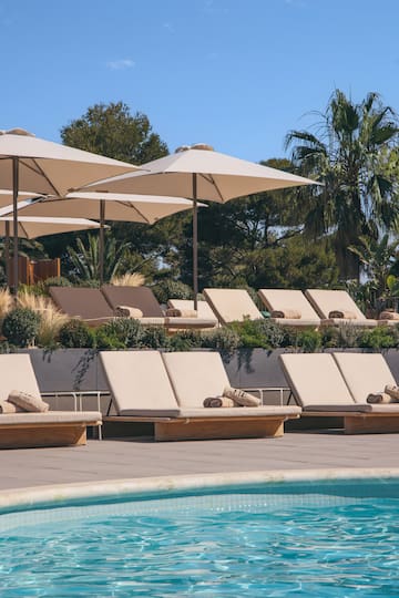 a pool with lounge chairs and umbrellas