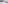 Modern hotel bedroom with white bed, dark headboard, and city view balcony.