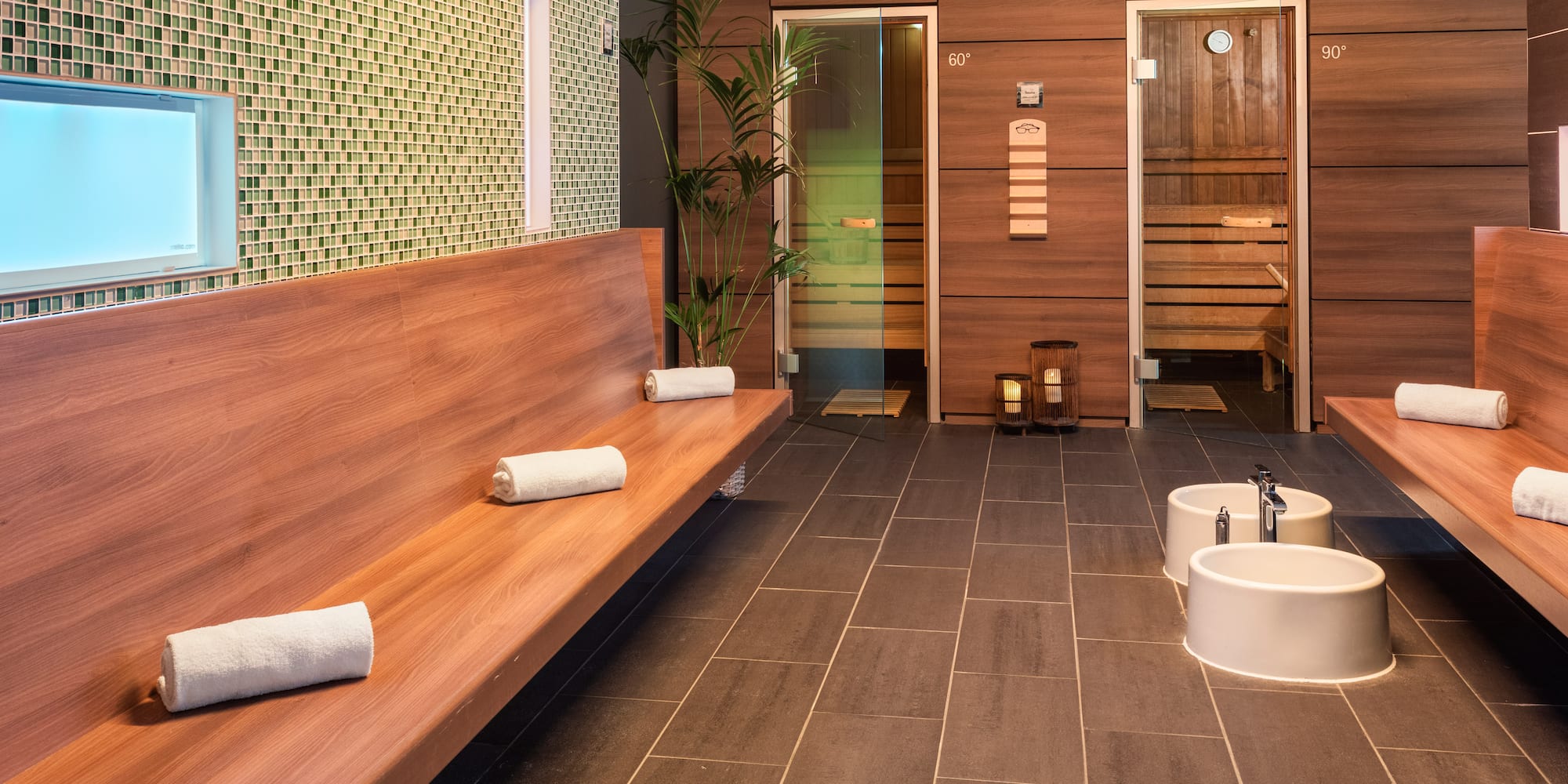 a room with a bench and sink and towels