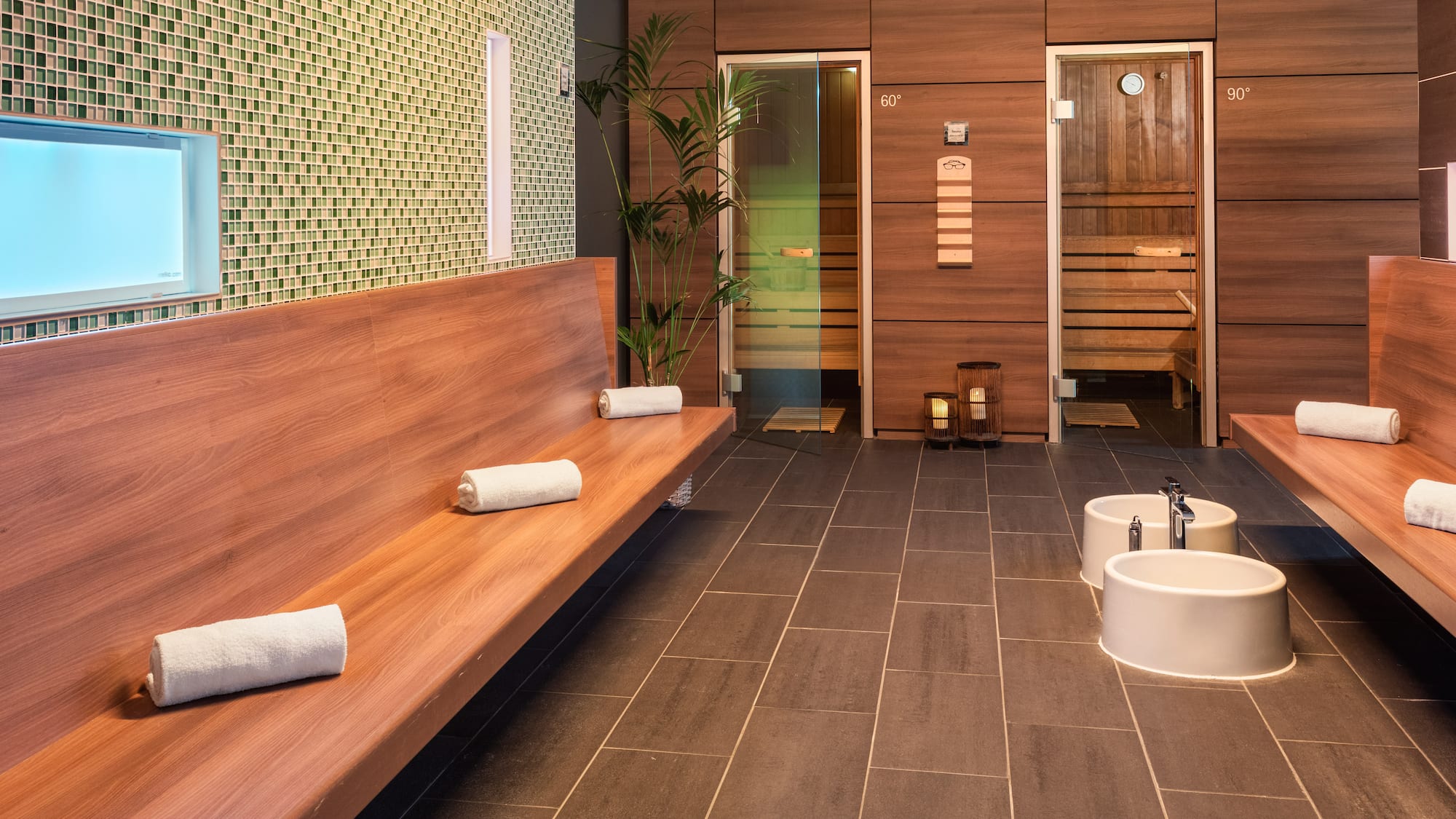 a room with a bench and sink and towels