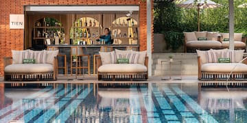 a pool with chairs and tables and a bar