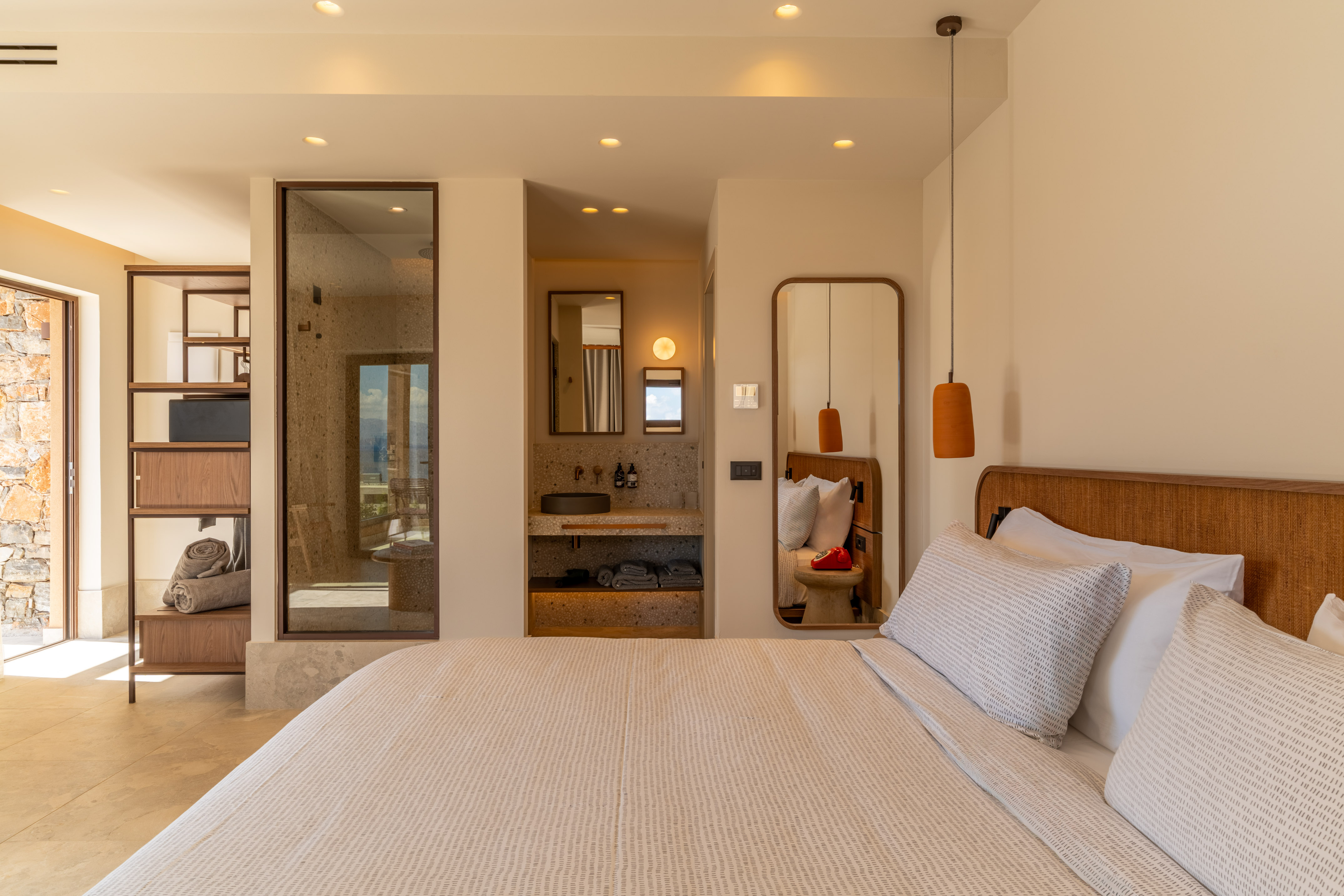 Modern hotel bedroom with open-plan bathroom, large bed, and contemporary decor.
