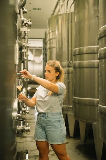 a woman holding a glass of liquid