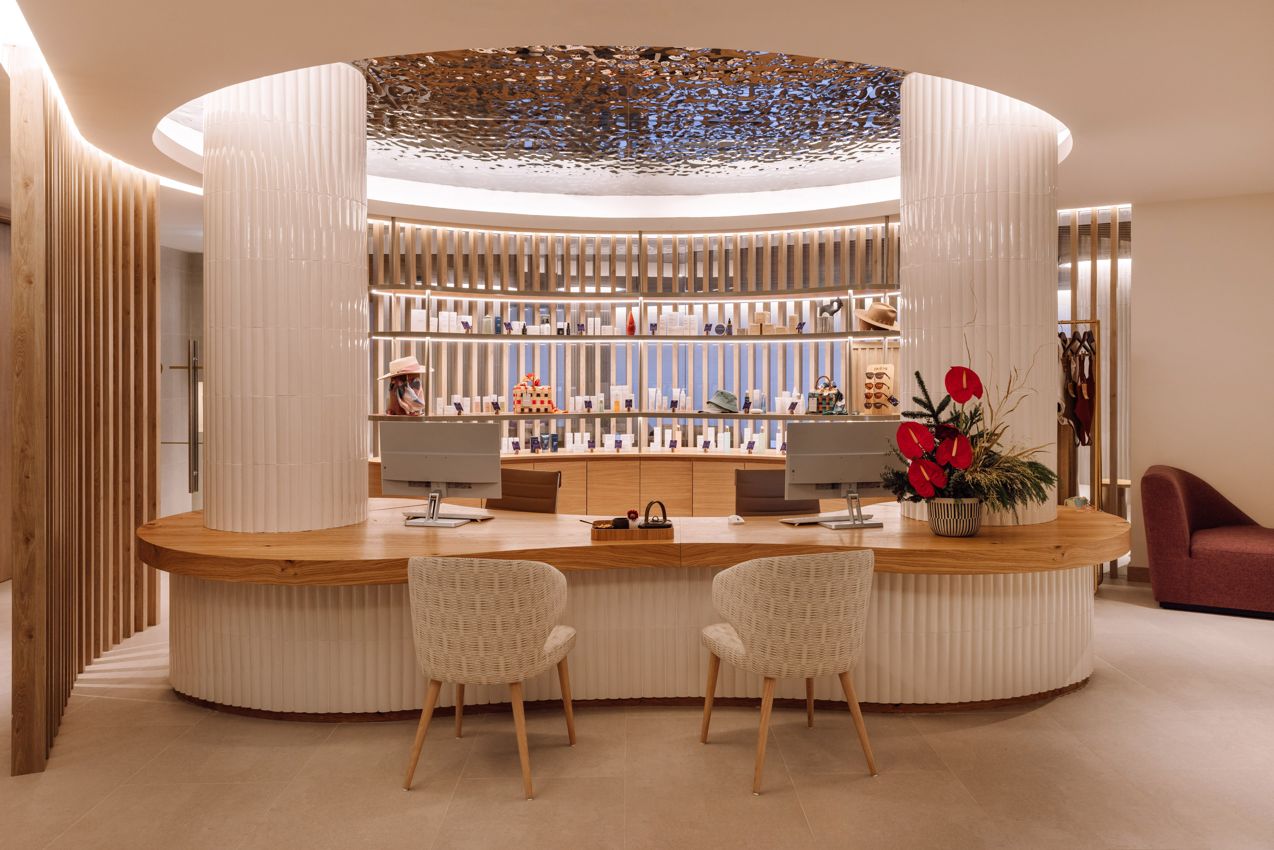 Modern spa reception desk, curved wood counter, retail product display.